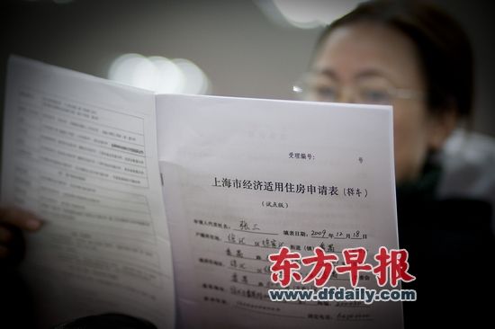 2009年12月18日，徐汇区田林社区服务中心，市民正在仔细阅读上海经济适用房申请表样本。徐晓林 早报资料